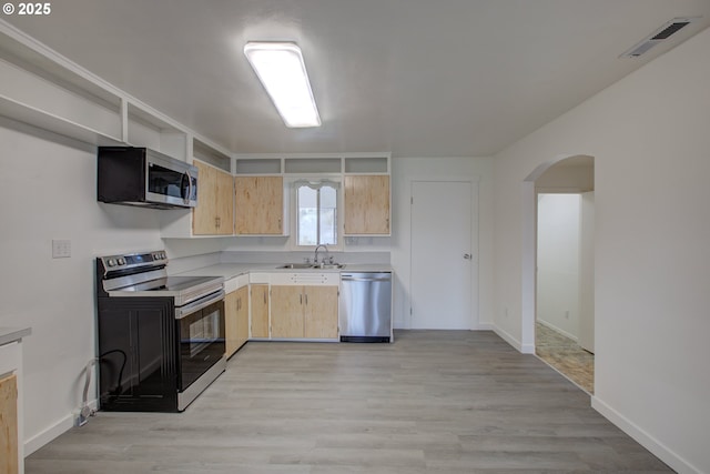 kitchen with sink, light brown cabinets, light wood-type flooring, and appliances with stainless steel finishes