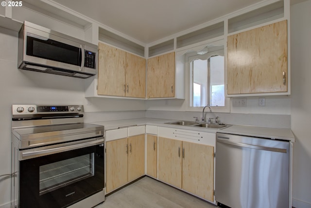 kitchen featuring sink, stainless steel appliances, light wood-type flooring, and light brown cabinets