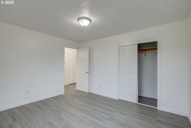 unfurnished bedroom featuring a closet and light hardwood / wood-style flooring