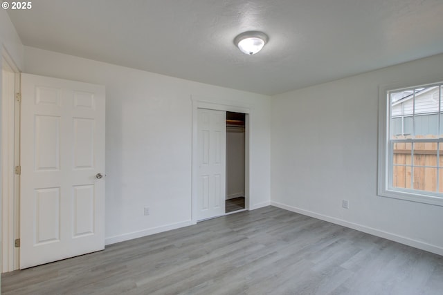 unfurnished bedroom featuring light hardwood / wood-style flooring and a closet