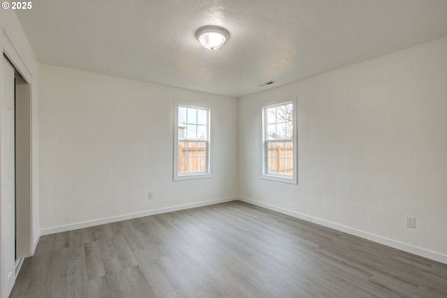 unfurnished bedroom featuring hardwood / wood-style flooring, a textured ceiling, and a closet