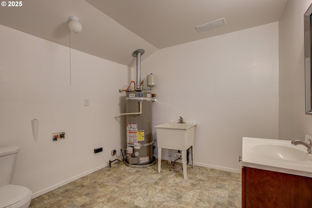 bathroom with toilet, lofted ceiling, vanity, and strapped water heater