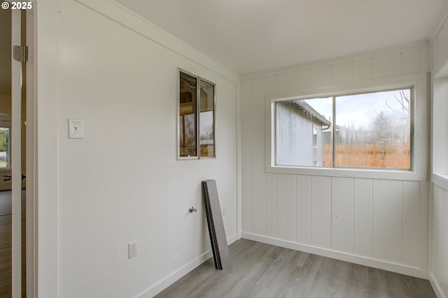 spare room featuring ornamental molding and light hardwood / wood-style floors