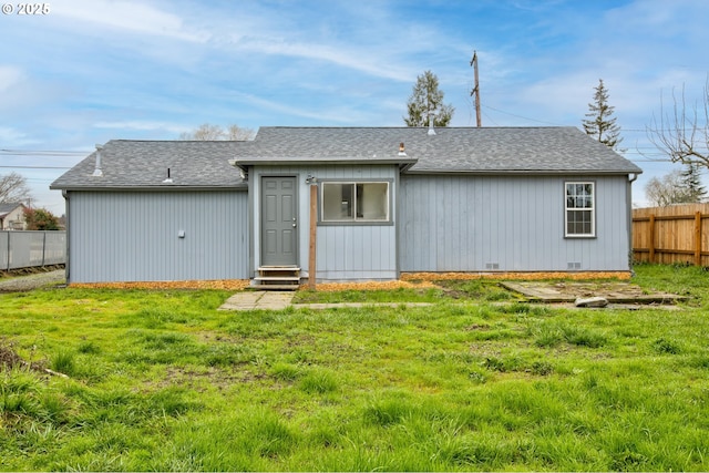 rear view of house featuring a lawn