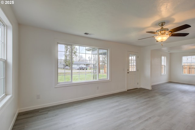 interior space featuring ceiling fan, light hardwood / wood-style floors, and a healthy amount of sunlight