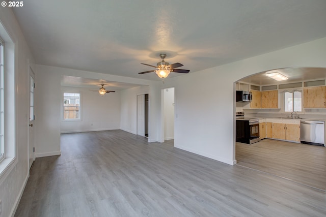 unfurnished living room with ceiling fan, light hardwood / wood-style flooring, and sink