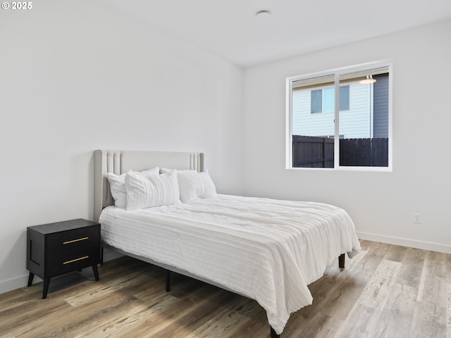 bedroom with wood finished floors and baseboards