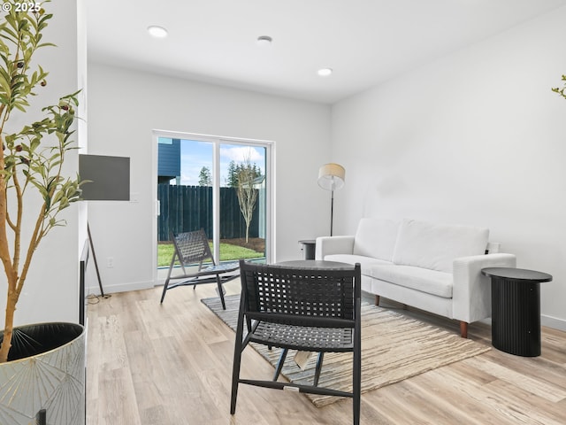 living room with recessed lighting, light wood-type flooring, and baseboards