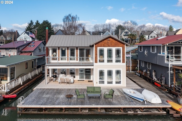 back of property featuring an outdoor hangout area and a deck with water view