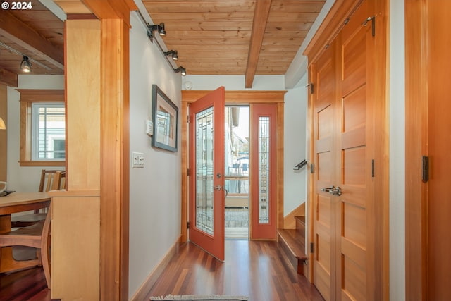 entrance foyer featuring rail lighting, beam ceiling, wooden ceiling, and dark wood-type flooring