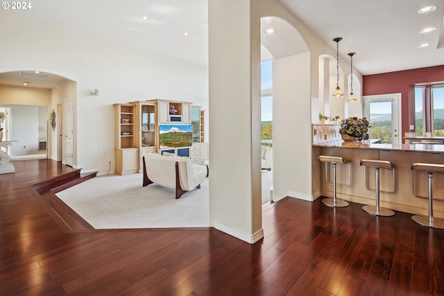 kitchen with double oven range, light stone counters, a breakfast bar area, and premium range hood