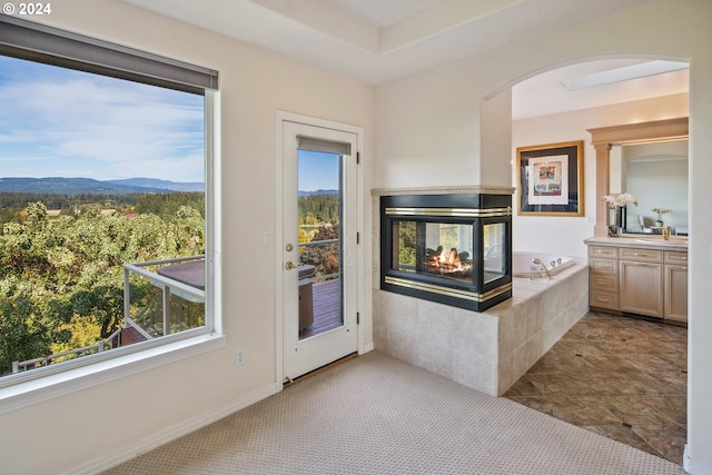 entryway featuring a multi sided fireplace and a mountain view