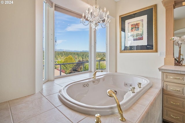 bathroom featuring a notable chandelier, a relaxing tiled tub, and vanity