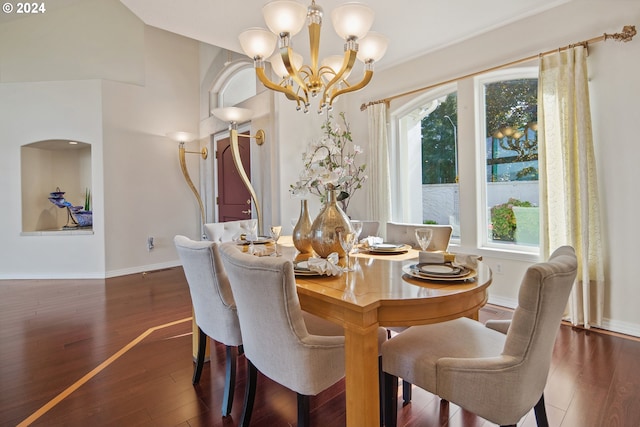 dining area with a healthy amount of sunlight, a notable chandelier, and dark hardwood / wood-style floors