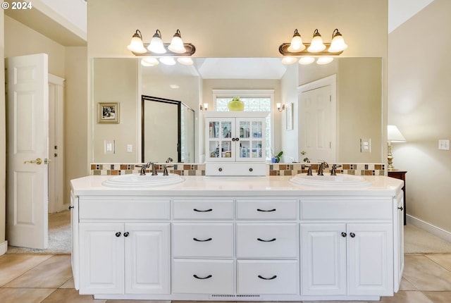 bathroom with tile patterned flooring, vanity, and a shower with door