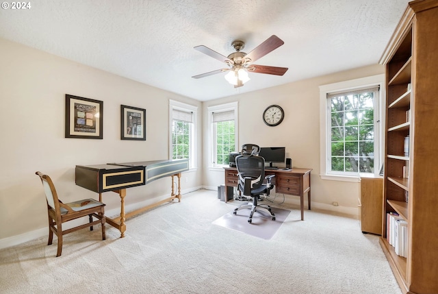 carpeted office space with ceiling fan and a textured ceiling