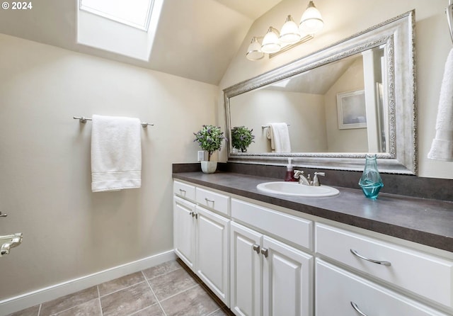 bathroom featuring vaulted ceiling with skylight, vanity, and tile patterned floors