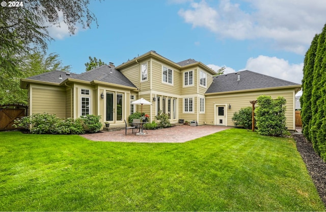 rear view of property with a yard and a patio