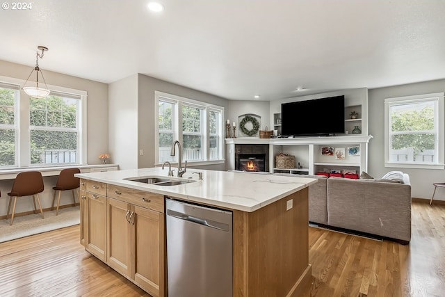 kitchen featuring dishwasher, a healthy amount of sunlight, and a center island with sink