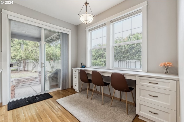 home office with built in desk and light wood-type flooring