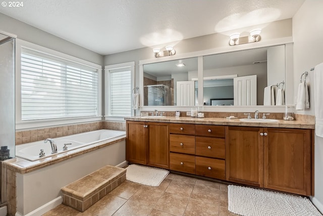 bathroom featuring vanity, a textured ceiling, plus walk in shower, and tile patterned floors