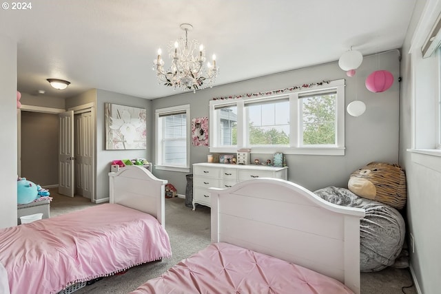 carpeted bedroom with a closet and a notable chandelier