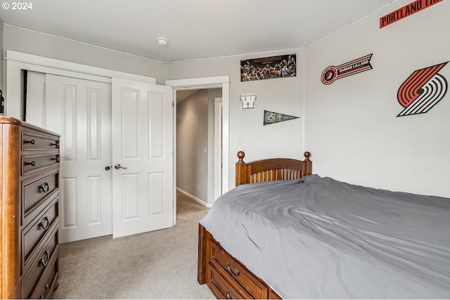 bedroom featuring light colored carpet and a closet