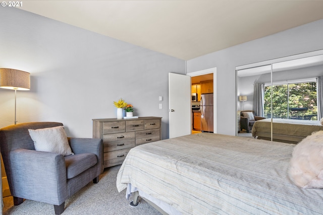 carpeted bedroom featuring stainless steel refrigerator and a closet