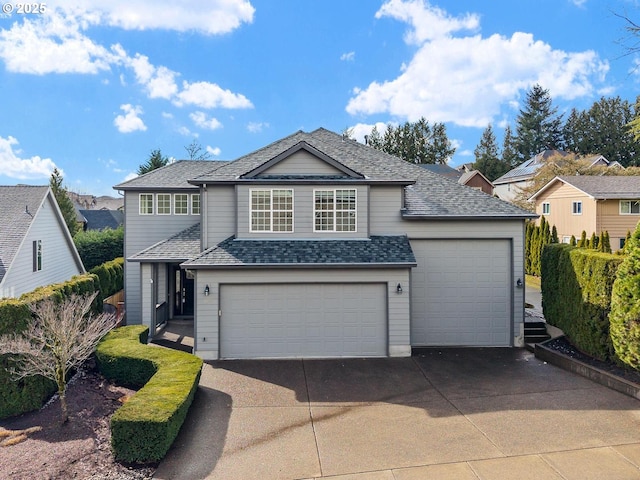 traditional-style house featuring roof with shingles, concrete driveway, and an attached garage