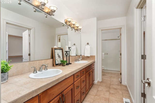 bathroom featuring double vanity, visible vents, toilet, and a sink