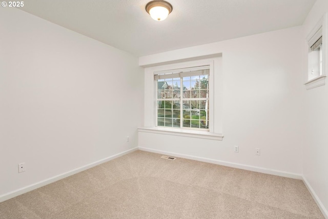 carpeted empty room with visible vents and baseboards