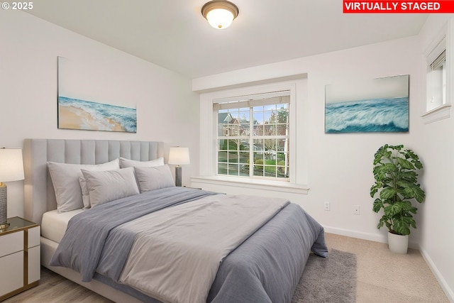 bedroom with baseboards and light carpet