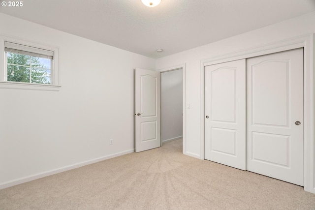 unfurnished bedroom featuring a closet, baseboards, and carpet