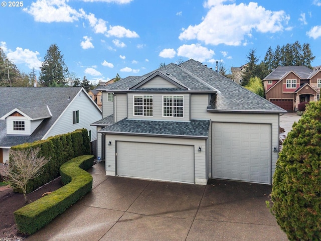 traditional-style home featuring an attached garage, driveway, and a shingled roof