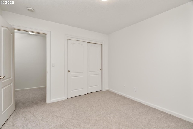 unfurnished bedroom with baseboards, a closet, and carpet floors