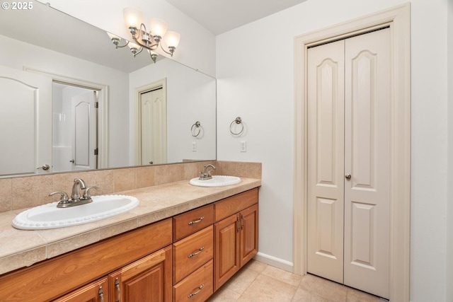 full bath with a sink, a closet, double vanity, and tile patterned flooring