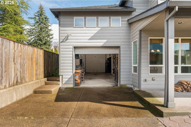 garage featuring driveway and fence