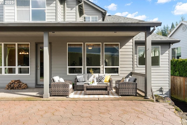 rear view of property with a patio area, outdoor lounge area, fence, and a shingled roof