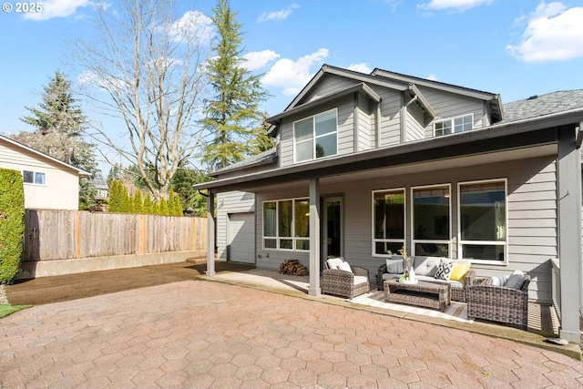 rear view of property with an outdoor hangout area, fence, and a patio area