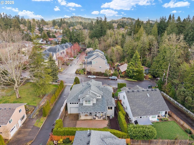 drone / aerial view featuring a residential view and a view of trees