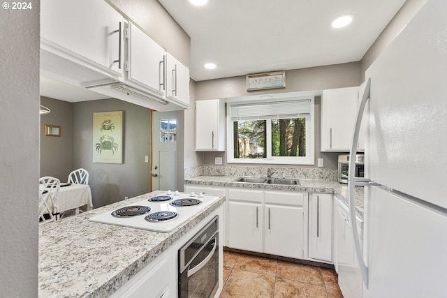 kitchen featuring light tile patterned floors, sink, white appliances, and white cabinetry