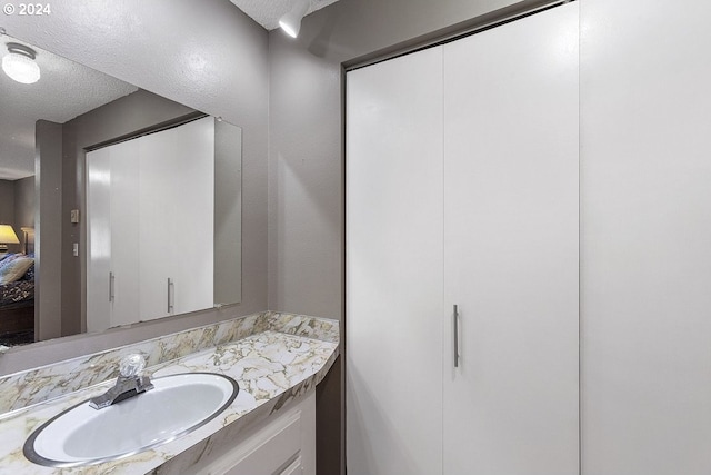 bathroom with vanity and a textured ceiling