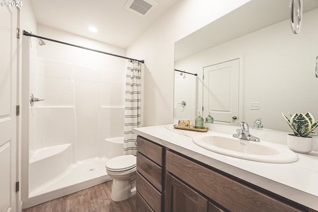 bathroom with toilet, hardwood / wood-style floors, curtained shower, and vanity