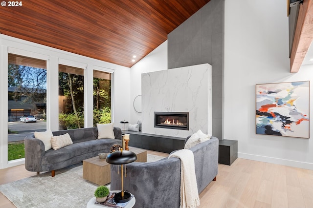 living room featuring a high end fireplace, vaulted ceiling, light wood-type flooring, and wooden ceiling