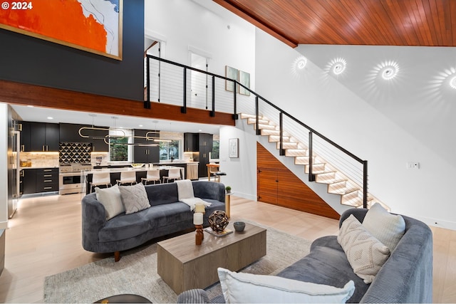 living room featuring light hardwood / wood-style flooring, wood ceiling, and high vaulted ceiling