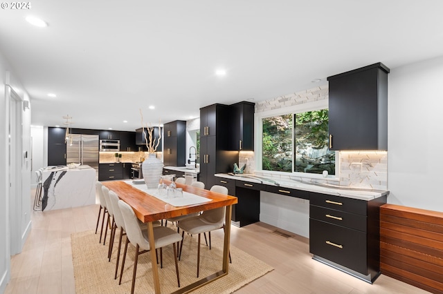 dining space with sink and light wood-type flooring