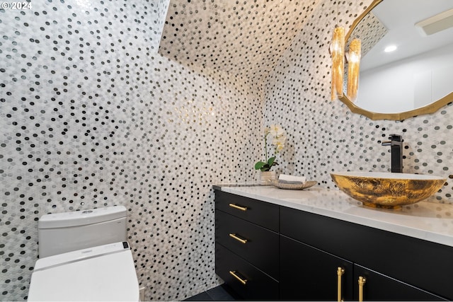 bathroom with vanity, toilet, and tile walls