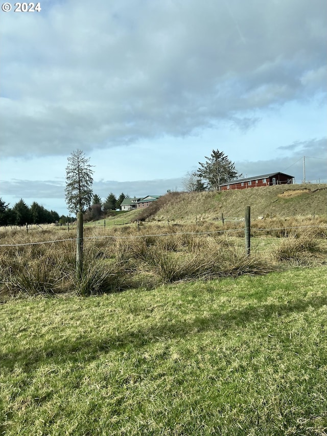 view of yard with a rural view and fence