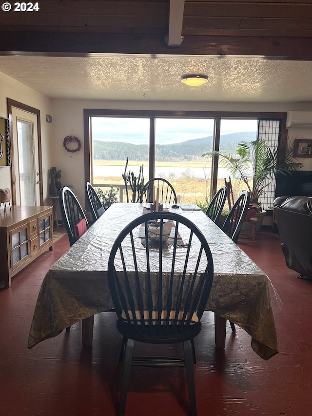 dining space with a textured ceiling, a wall mounted air conditioner, and a wealth of natural light