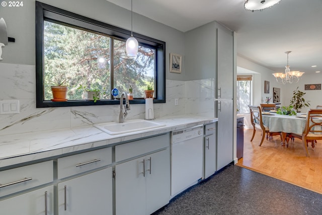 kitchen featuring hanging light fixtures, dishwasher, dark hardwood / wood-style floors, and plenty of natural light